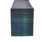 Plaid blanket in green, teal, navy and purple tones; woven tartan fabric shown as a rectangular throw for home decor.