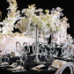 Set of 2 Metal Trumpet Centerpiece Vases Silver table setting with white florals, glass goblets, and silver table accents