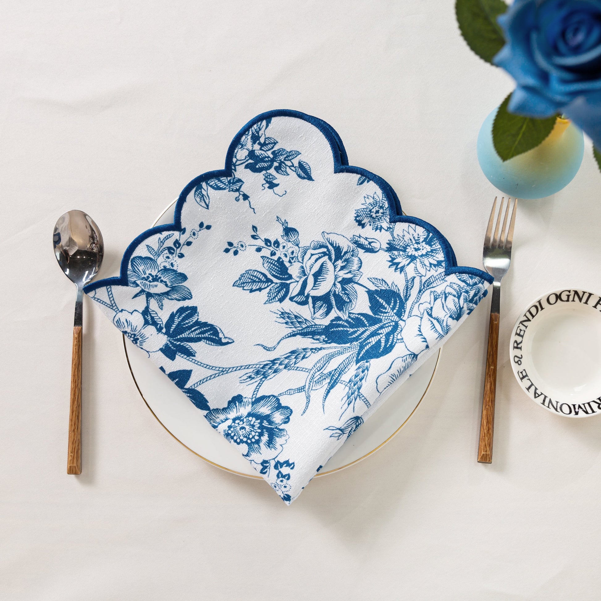 4 pcs/pk French Toile 20"x20" Scalloped Edge Napkins Blue folded on top a white gold trimmed dinner plate