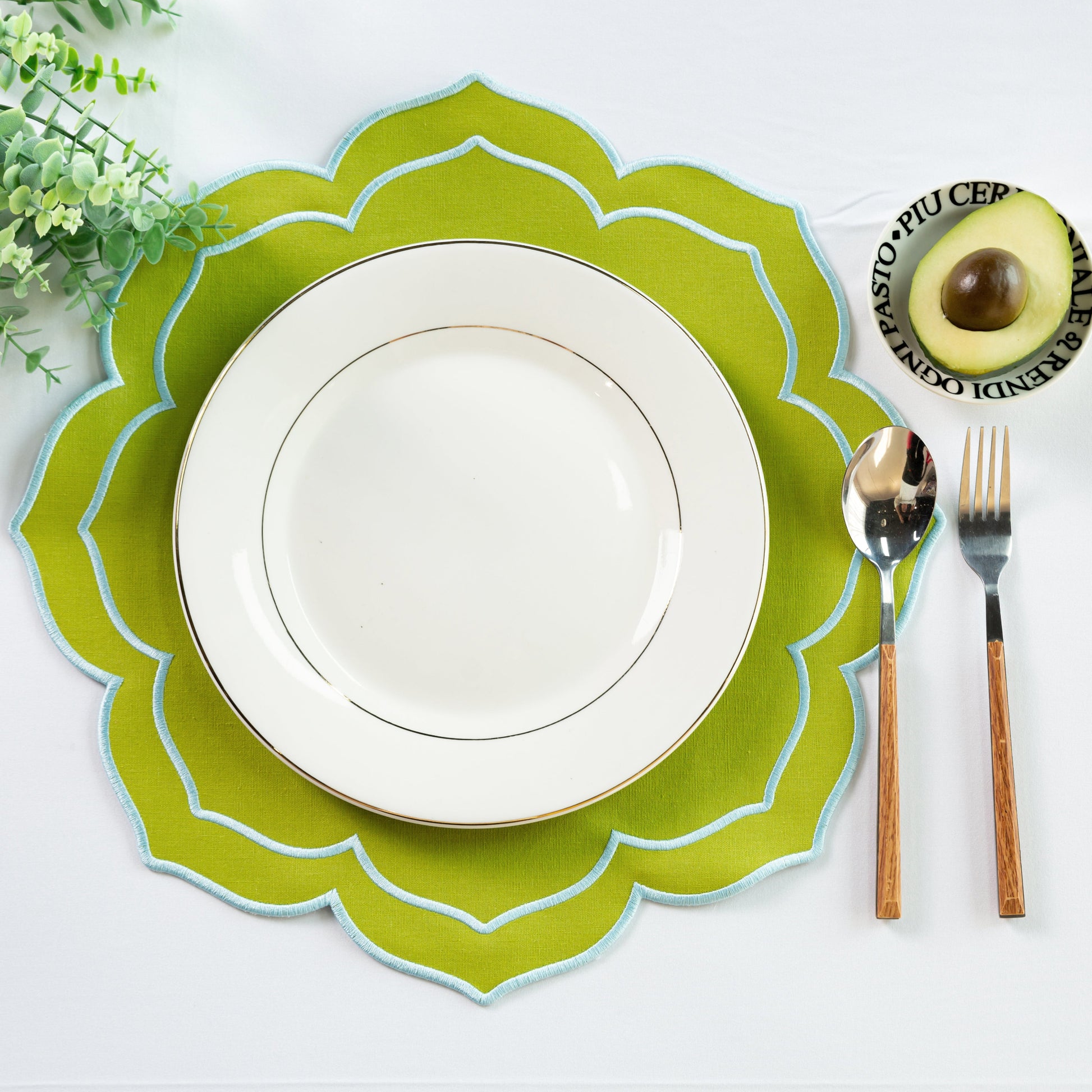4pc/set Petal Elegance Placemats - Matcha/Turquoise Trim paired with a white tablecloth, white dinner plate, faux greenery and silverware