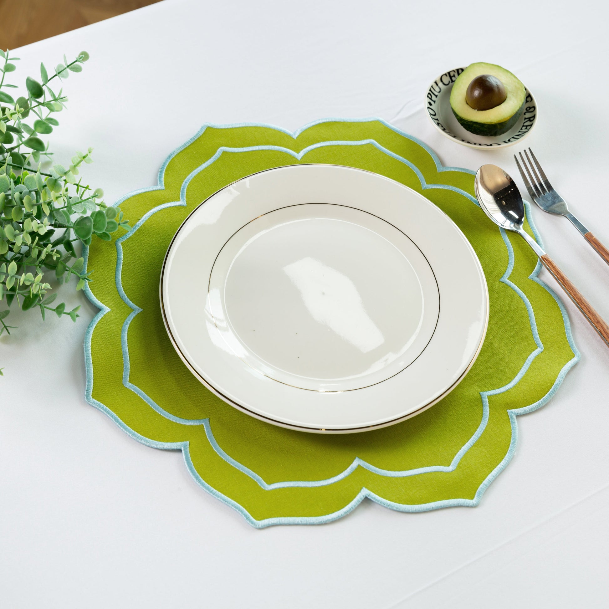 4pc/set Petal Elegance Placemats - Matcha/Turquoise Trim paired with a white tablecloth, white dinner plate, faux greenery and silverware