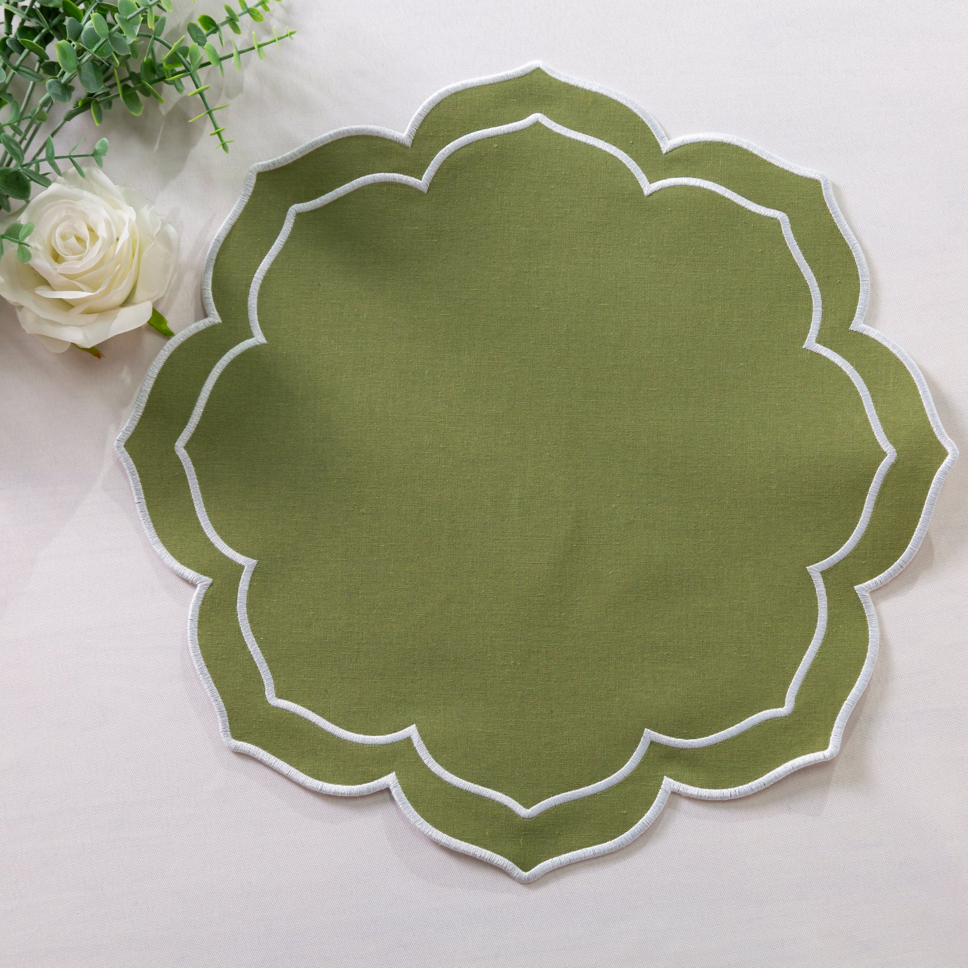 4pc/set Petal Elegance Placemats - Olive Green/White Trim paired with faux greenery, and a white tablecloth