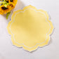 Petal Elegance Placemats - Pastel Yellow/White Trim on top of a white tablecloth and sunflowers
