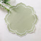 Petal Elegance Placemats - Sage Green/White Trim on top a white tablecloth with faux greenery