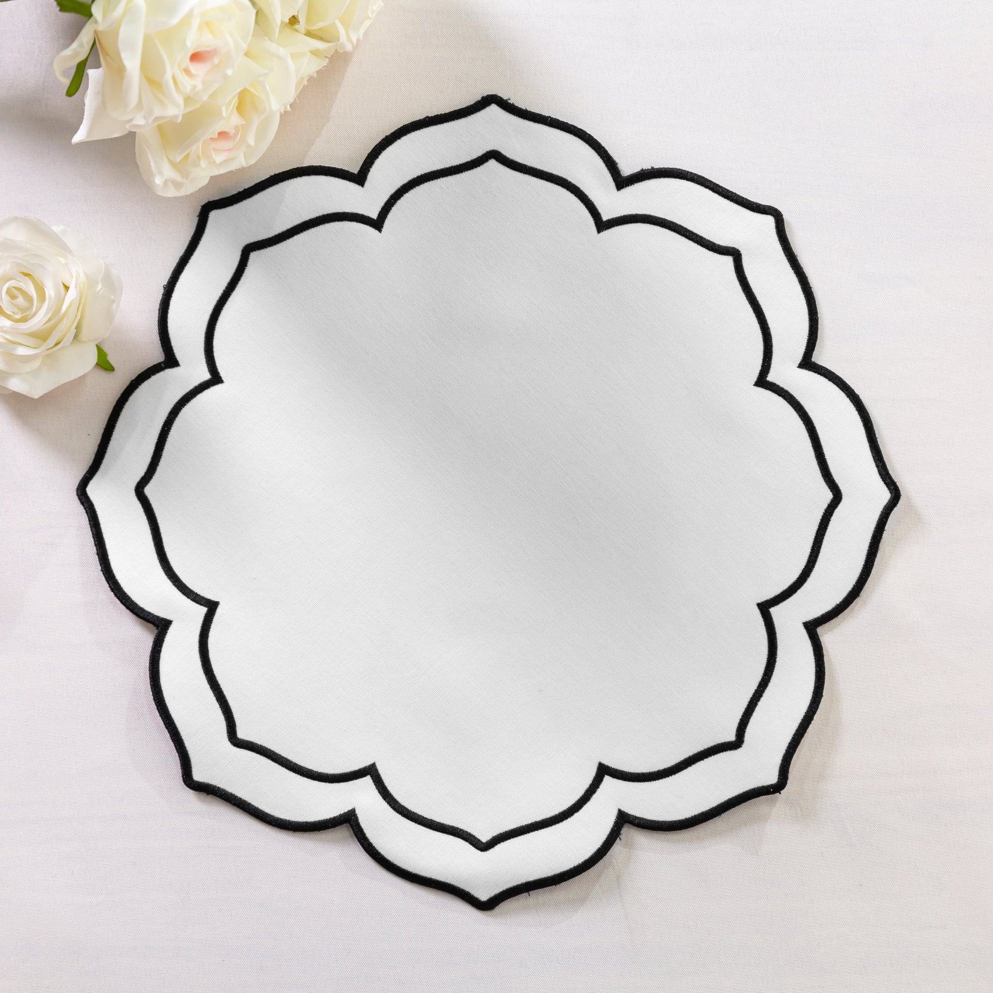 4pc/set Petal Elegance Placemats - White/Black Trim paired white roses, on top a white tablecloth