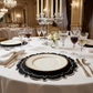 dinner table set with the 4pc/set Signature Scallop Placemats Black/White Trim white gold trimmed charger plate, and wine glasses