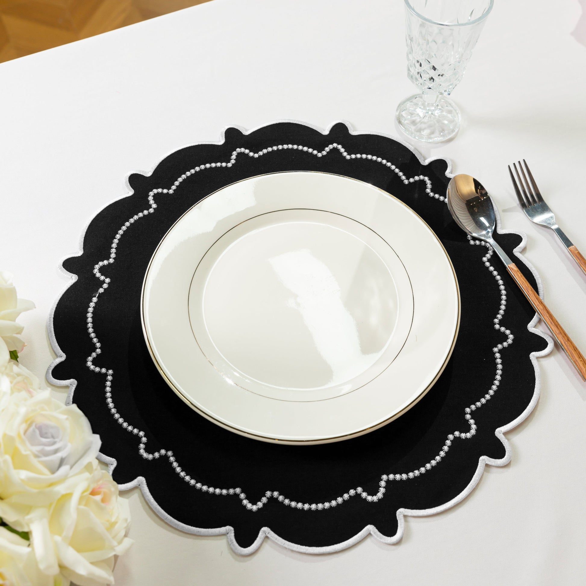 4pc/set Signature Scallop Placemats Black/White with white dinner plate, silverware, wine goblet and florals