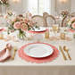 brunch table setting with the 4pc/set Signature Scallop Placemats Coral/White Trim with white dinner plates, gold flatware, and pink floral centerpieces