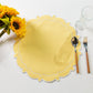4pc/set Signature Scallop Placemats Pastel Yellow/White paired with sunflowers, silverware, and wine goblet