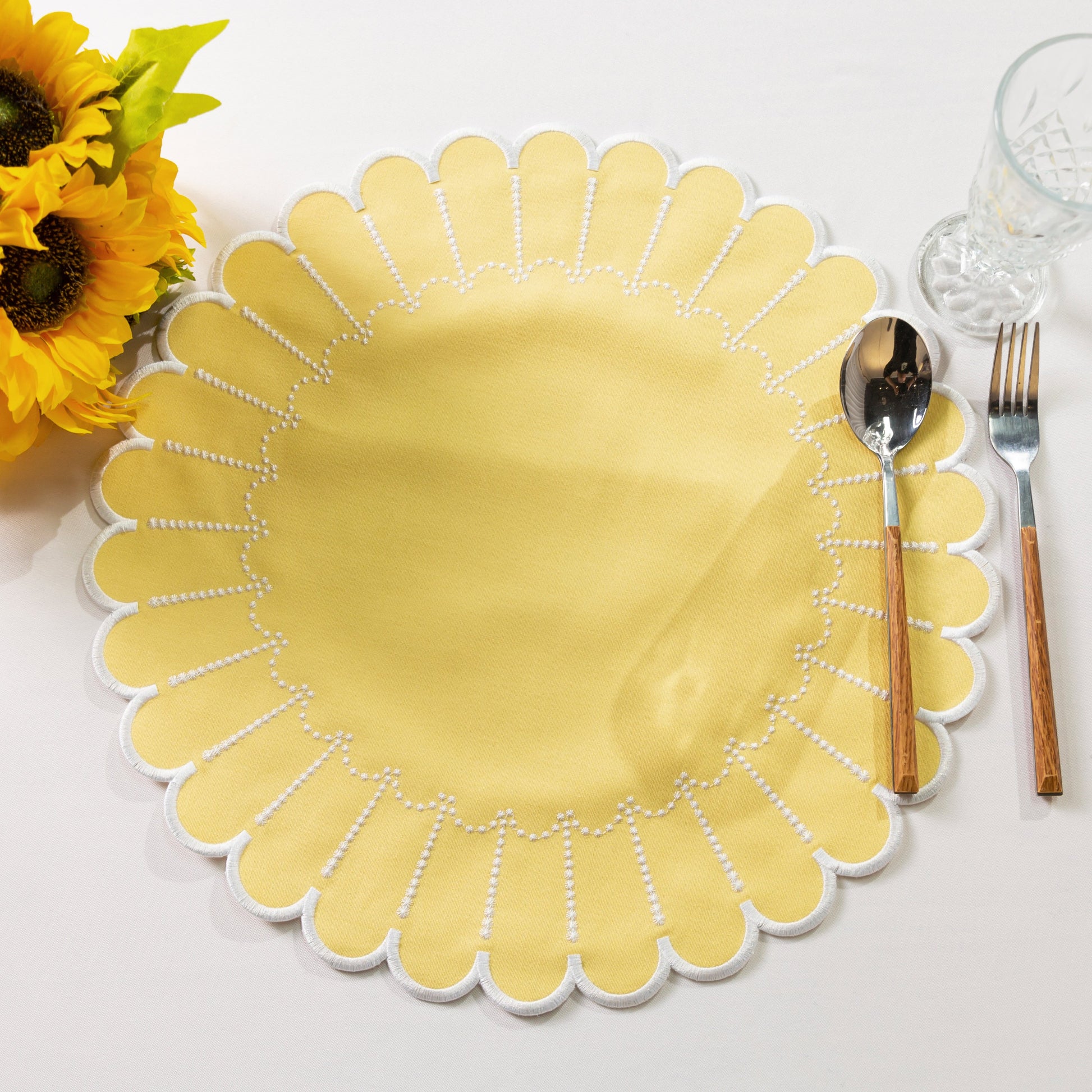 4pc/set Sunburst Edge Placemats Pastel Yellow/White Trim paired with florals, silverware on a white tablecloth