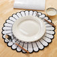 4pc/set Sunburst Edge Placemats White/Black Trim paired with white dinner plate, and silverware