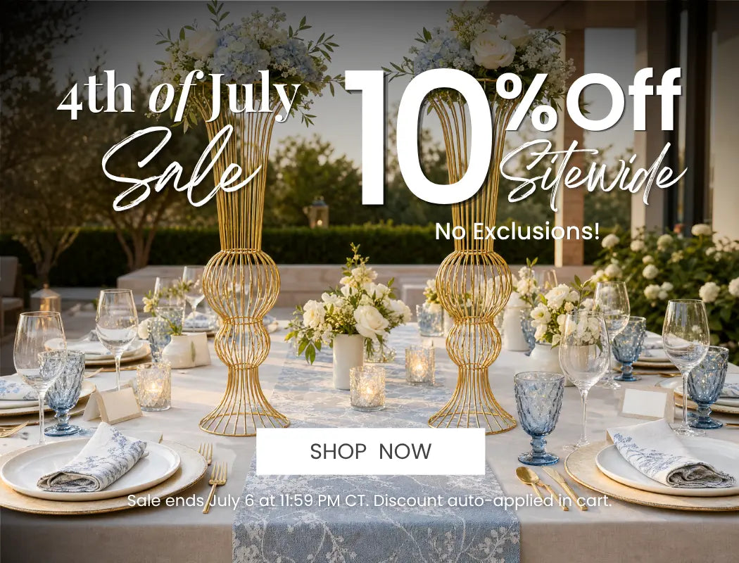 4th of July sale banner: formal dining table with gold centerpiece vases, white florals, blue glassware, 10% off sitewide.