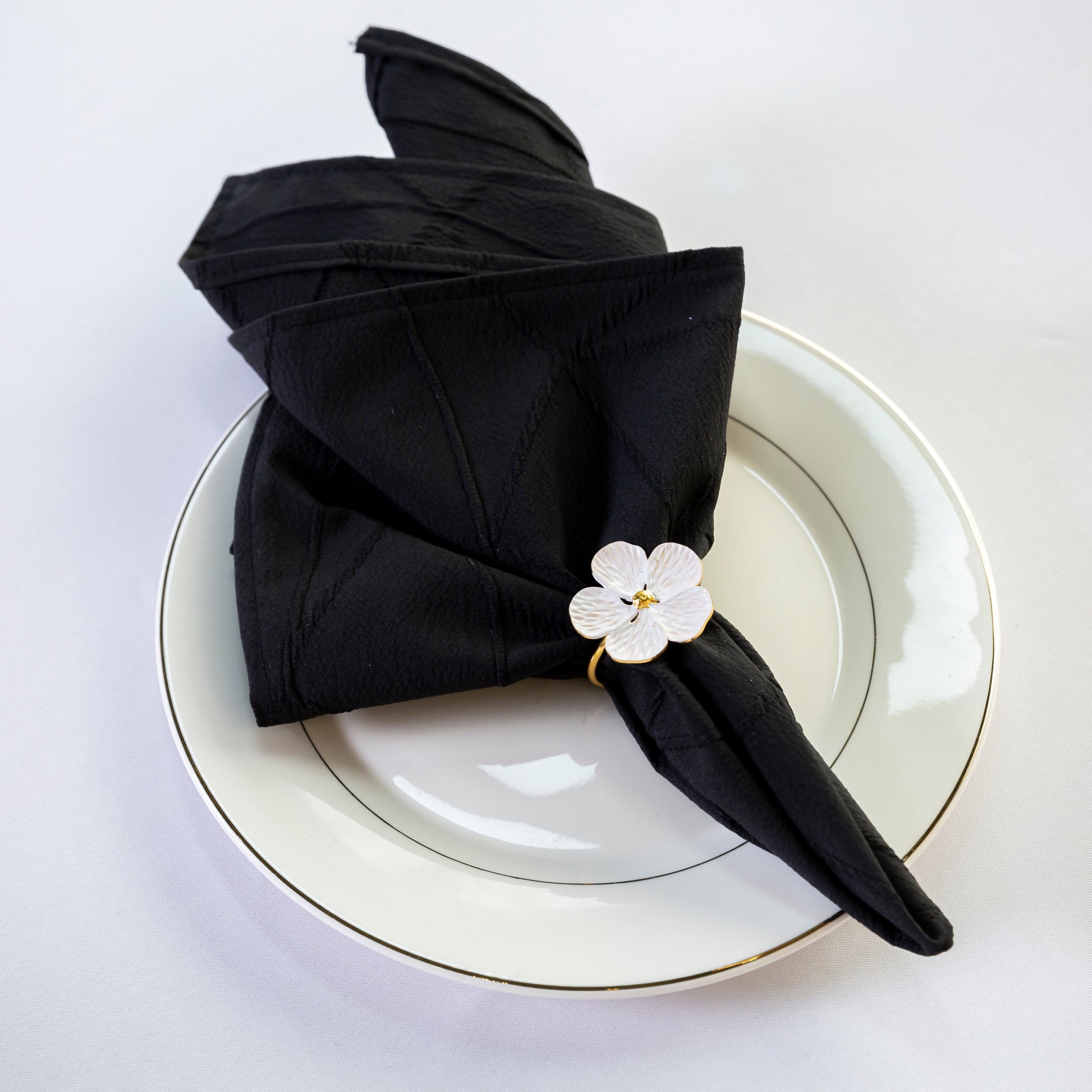 5 pcs/pk Embossed Geometric Jacquard Napkin 20"x20" Black fan fold with a white flower napkin ring