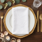 Embossed Geometric Jacquard Napkin 20"x20" White on top of gold charger plate, gold silverware, pearls, and votive candle