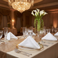 5 pcs/pkEmbossed Geometric Jacquard Napkin 20"x20" White on top of clear with gold trim charger plates, silverware, blush/rose gold glitz mesh table runner and calla lily floral centerpiece