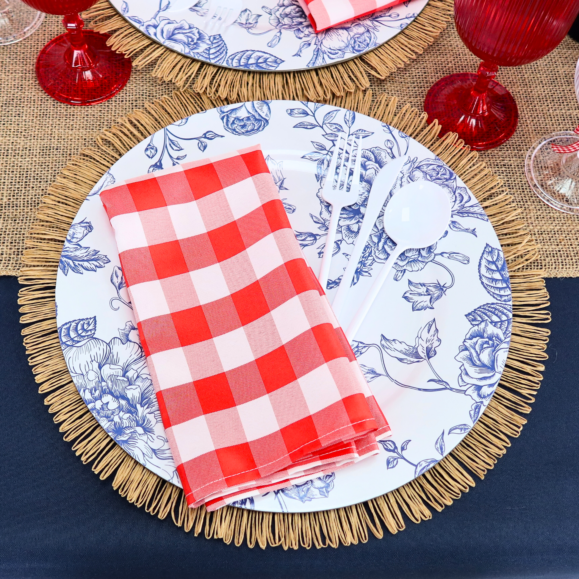 5pcs Gingham Checkered Polyester Napkin 20"x20" Red & White paired with red goblets, blue french toile charger plates, and fringed edge woven 15" placemats