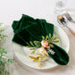 5 pcs/pk Glitter Velvet 20"x20" Linen Napkin Emerald Green paired with a white charger plate, faux floral napkin ring and silverware