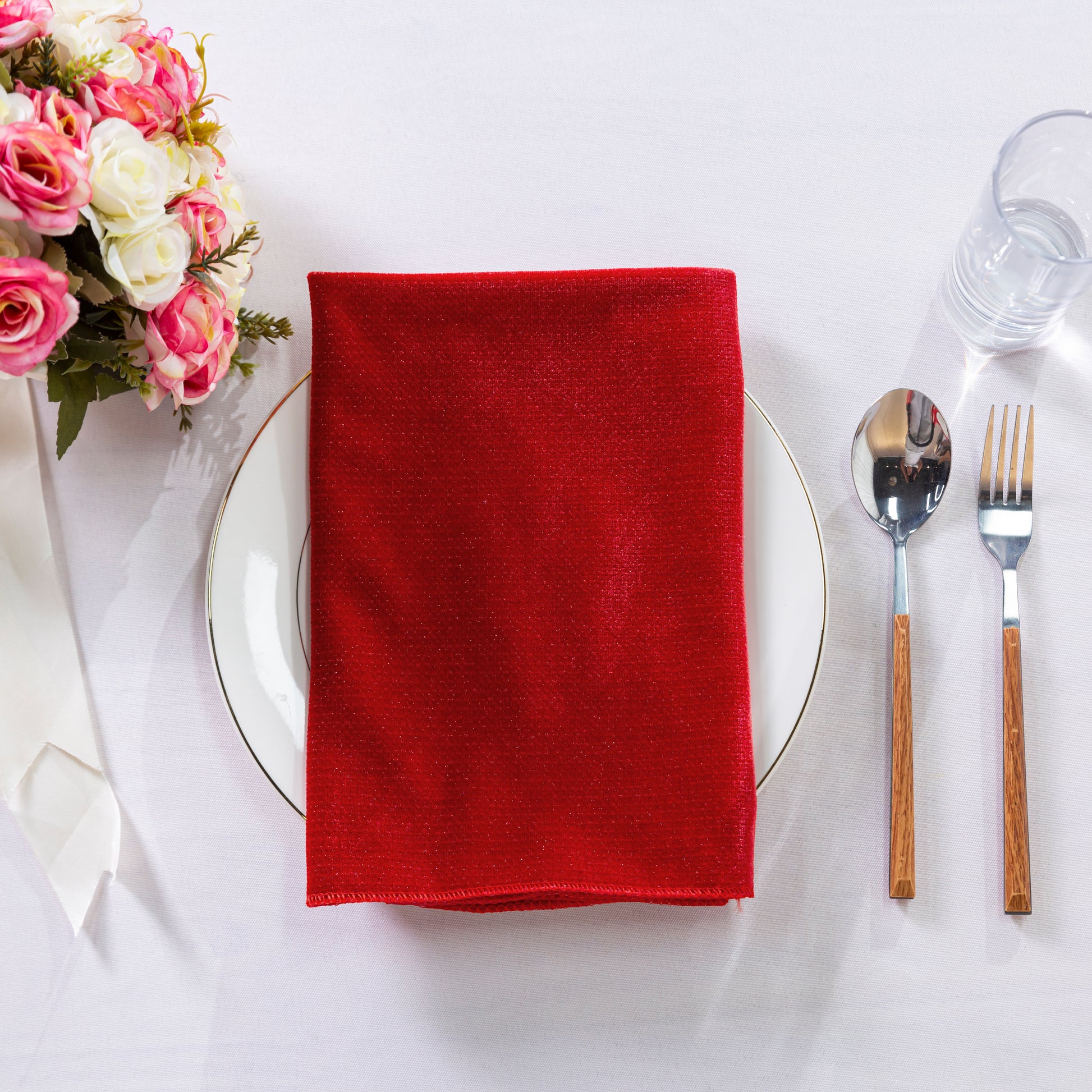 5 pcs/pk Glitter Velvet 20"x20" Linen Napkin Red folded on a white charger plate, sunflowers and silverware