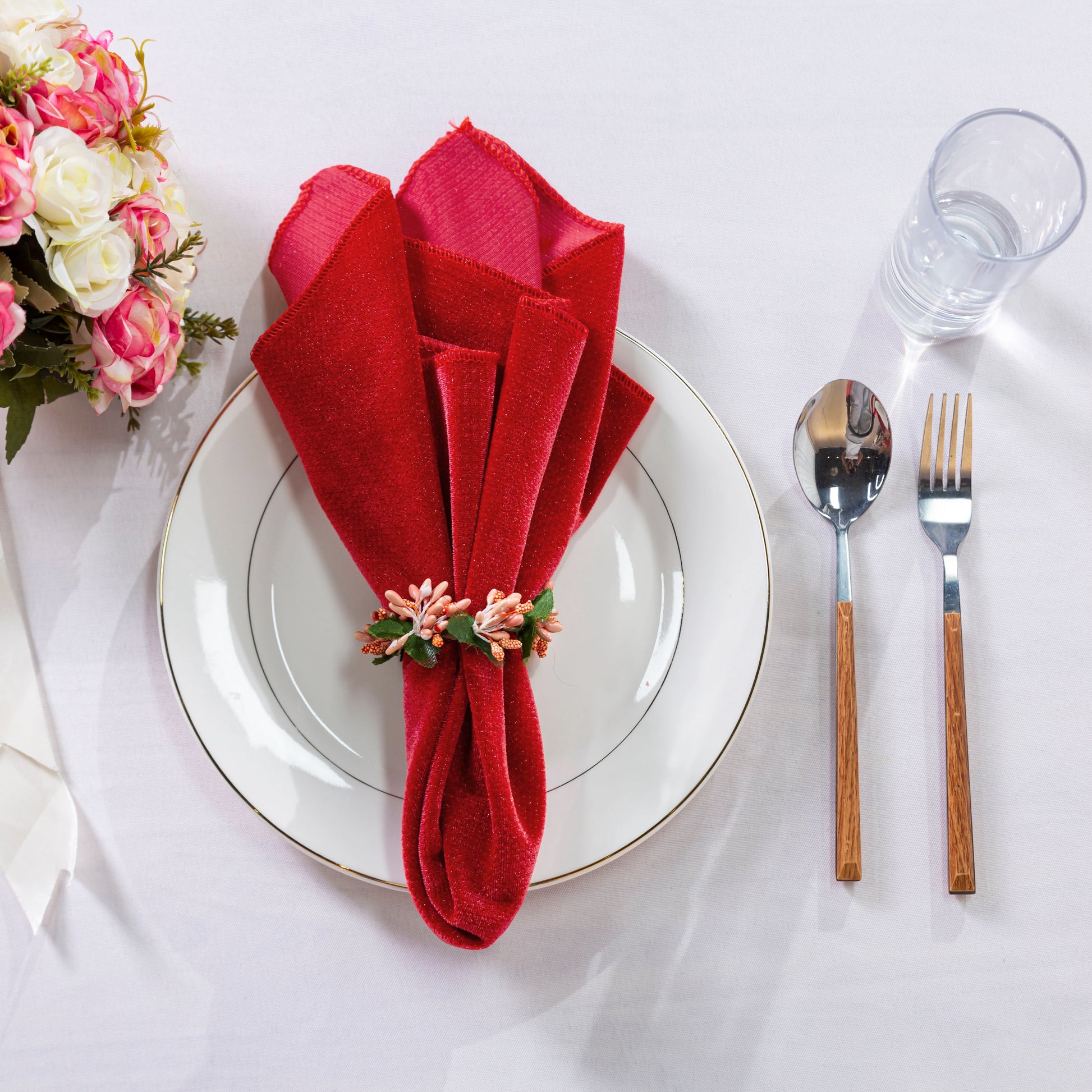 5 pcs/pk Glitter Velvet 20"x20" Linen Napkin Red paired with a napkin ring, white charger plate, rose florals and silverware