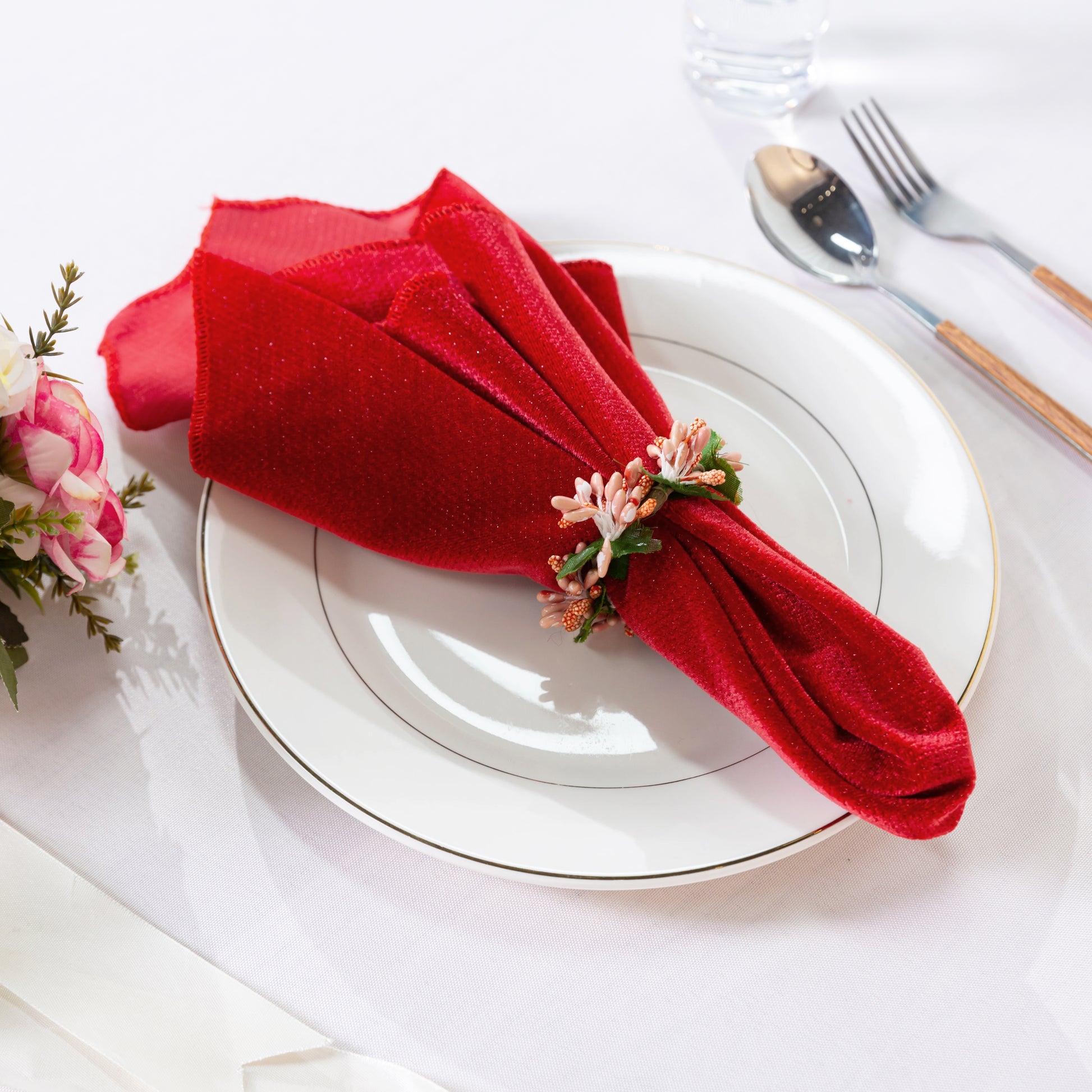 5 pcs/pk Glitter Velvet 20"x20" Linen Napkin Red paired with a napkin ring, white charger plate, rose florals and silverware