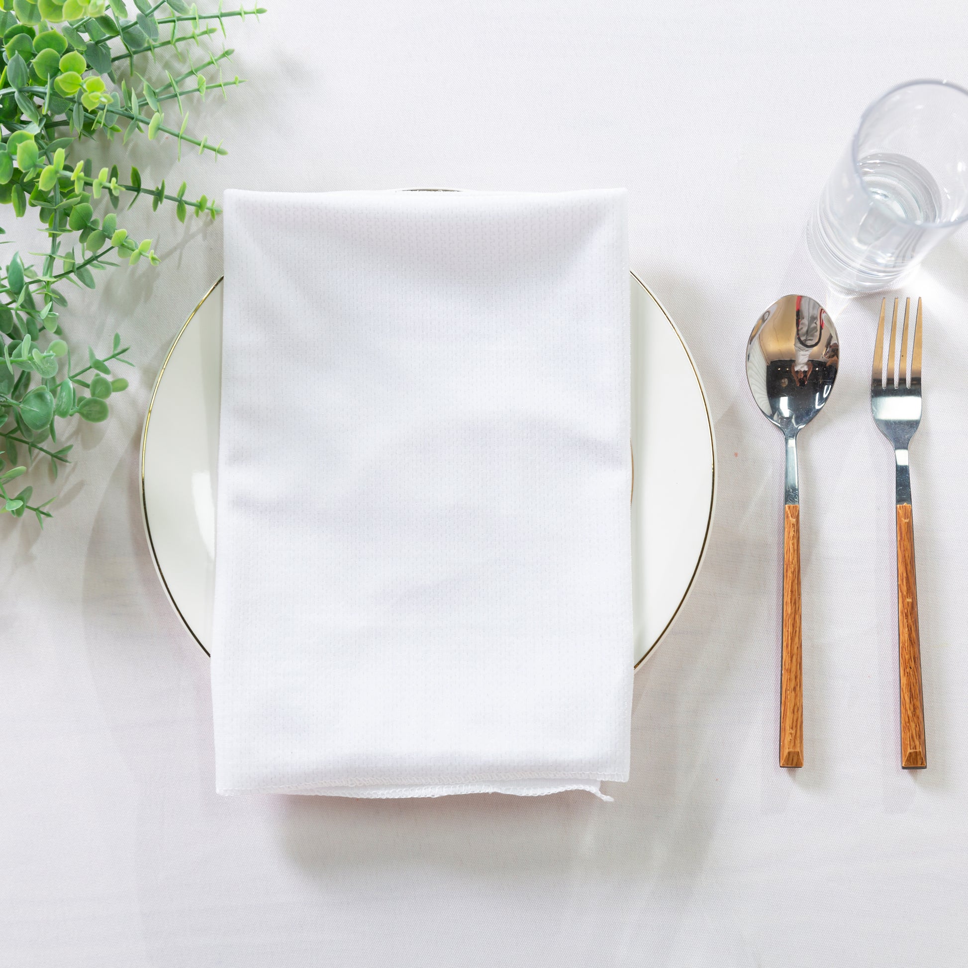 5 pcs/pk Glitter Velvet 20"x20" Linen Napkin White folded on a white charger plate, grennery and silverware