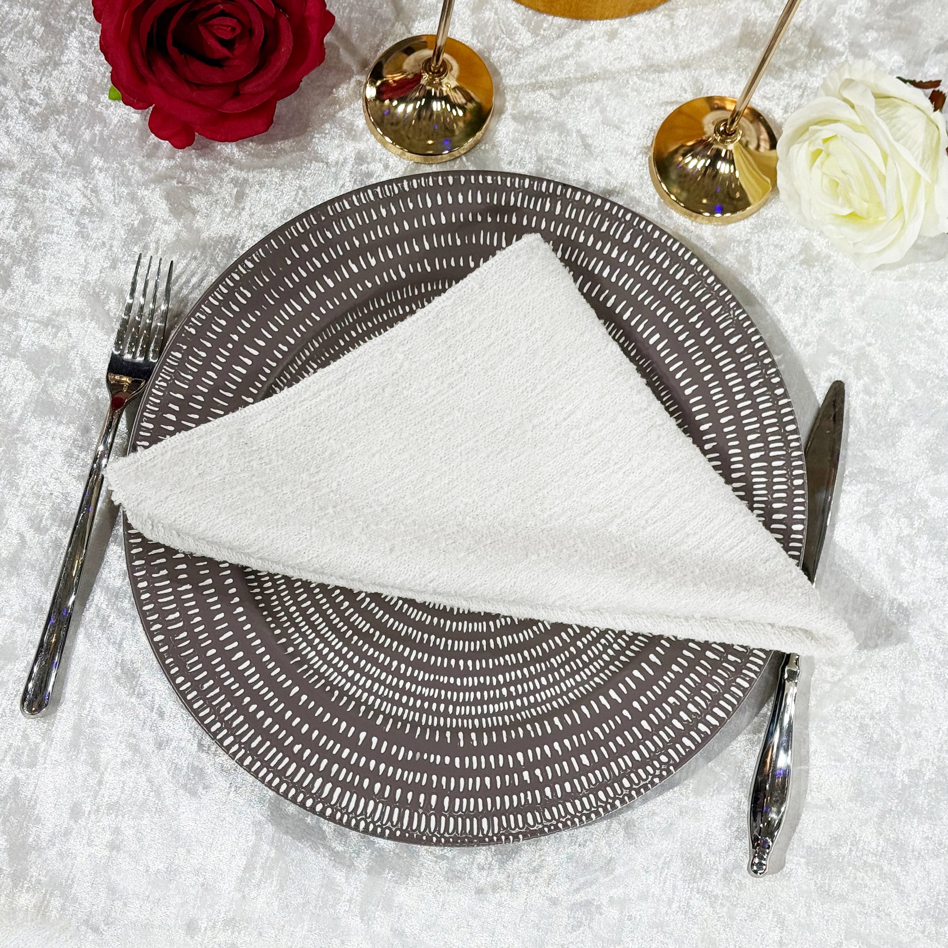 5 pcs/pk Luxury Boucle 20"x20" Linen Napkin White folded on top of a patterned  charger plate
