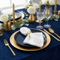 5 pcs/pk Luxury Boucle 20"x20" Linen Napkin White with a gold napkin ring on top of a blue dinner pate and gold charger plate
