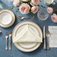 French Chateau theme with the Embossed Geometric Jacquard Napkin 20"x20" Light Ivory/Off White, flat triangle envelope fold on top a white with gold trim dinner plate, and pink peony floral centerpiece
