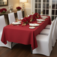 60"x120" Rectangular Premium Polyester Tablecloth - Apple Red on top of 6ft rectangular table| white chair cover | white dinner and charger plate