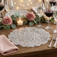 8 pc/set Filigree Acrylic Charger Plate Clear on a wooden table with wine goblets, and floral greenery table runner