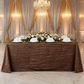 bridal table with the Accordion Crinkle Taffeta Rectangular Tablecloth infront of a pipe and drape set backdrop and hanging chandeliers