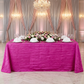 bridal table with the Accordion Crinkle Taffeta Rectangular Tablecloth Fuchsia with white napkins in a fan fold and a floral table runner