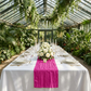 garden reception table with the Accordion Crinkle Taffeta Table Runner Fuchsia on top a white tablecloth, wine glasses, and floral centerpieces