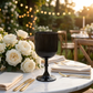 single Black Acrylic 11oz Wine Goblets Ripple Design on top a marble table, with beige napkins, gold silverware and white roses