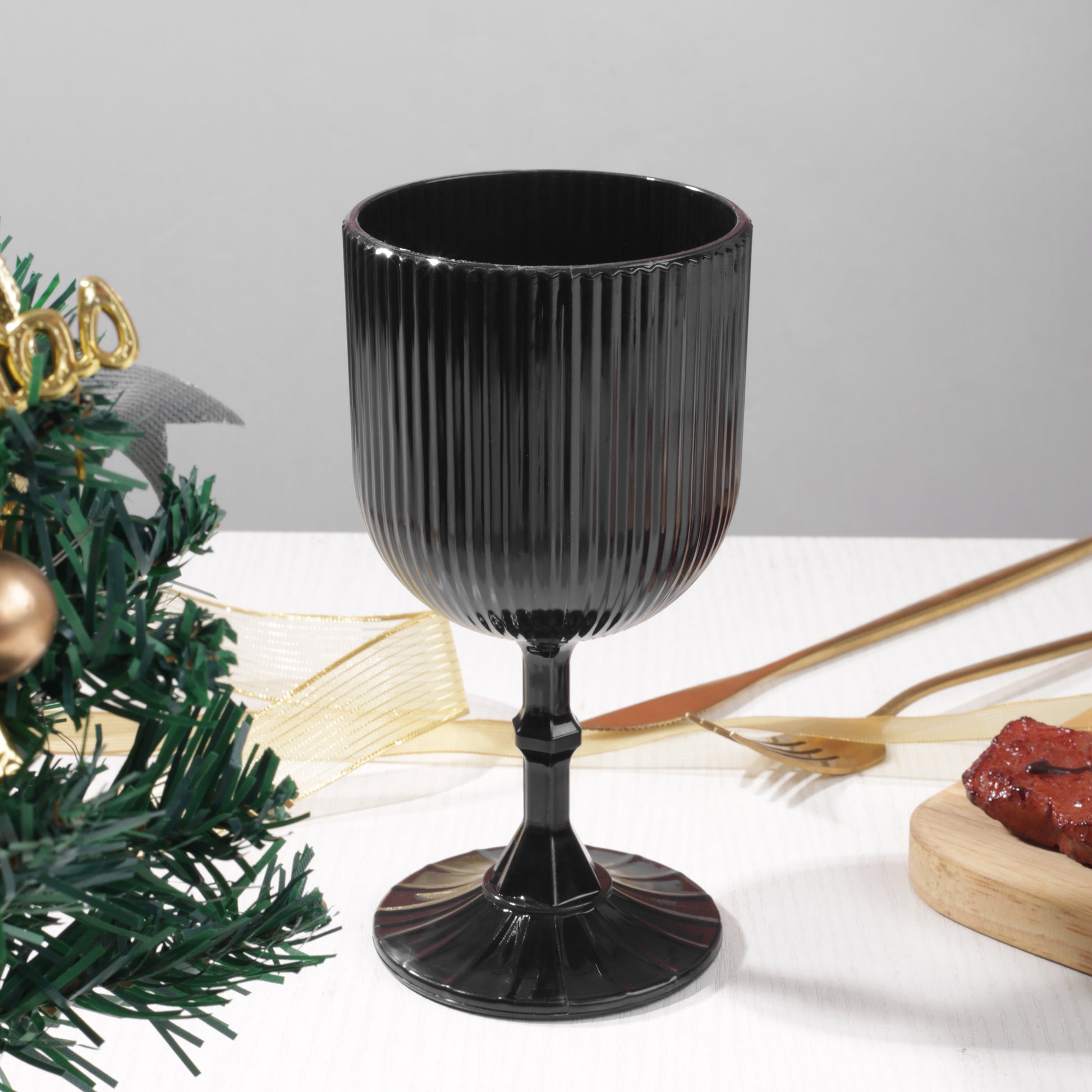 Black Acrylic 11oz Wine Goblets Ripple Design (6 pcs/pk) on a table with gold silveware and christmas greens on top a white tabelcloth