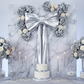 Giant Fabric Bow for Backdrop Metallic Silver against a marble backdrop with silver hydrangeas and white roses for a birthday