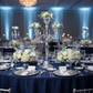 Candelabra Centerpiece with Hanging Crystals - Silver with flowers for corporate dinner with navy blue tablecloth | silver charger plate | wine goblets
