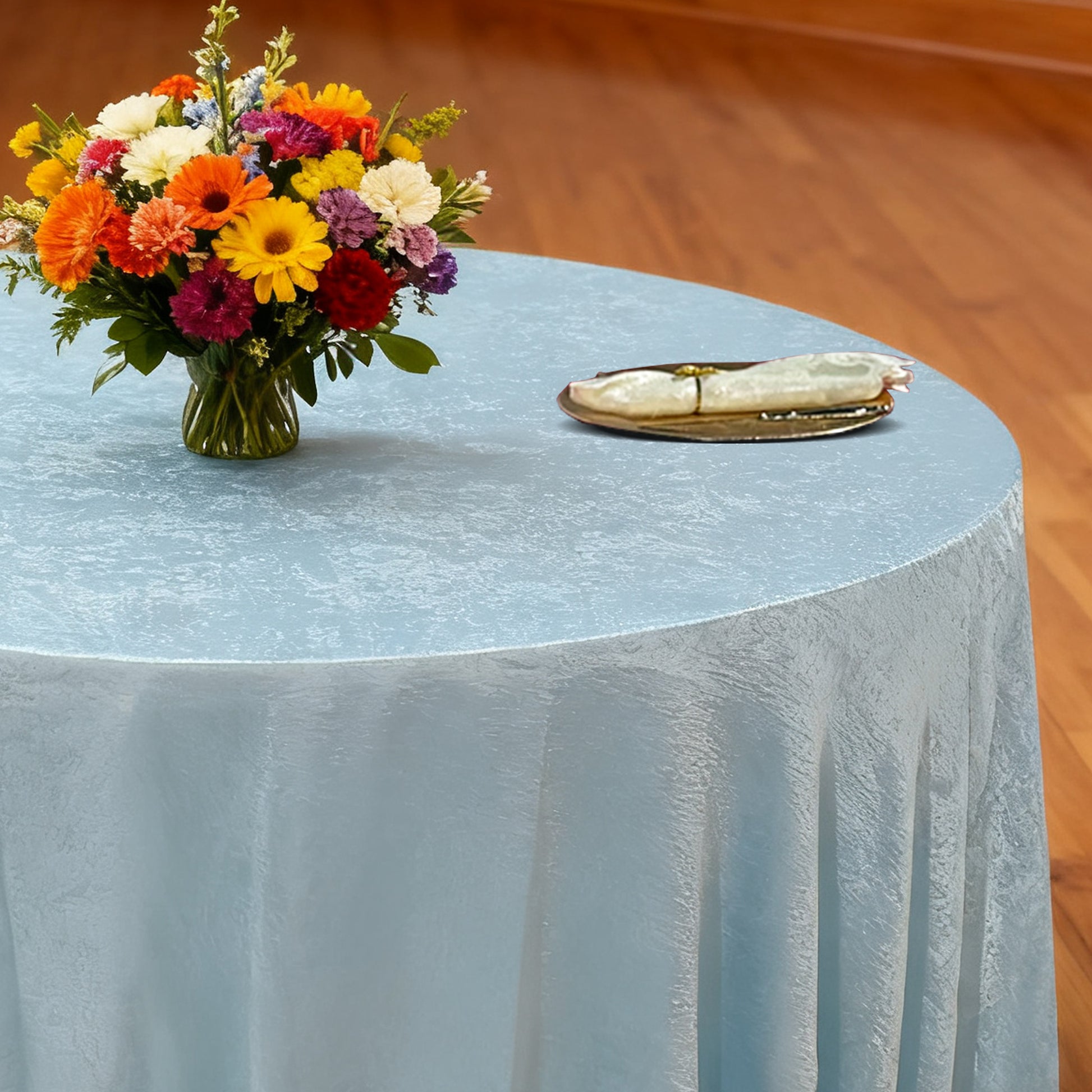 Crinkle Shimmer 120" Round Tablecloth Baby Blue with floral centerpiece, gold charger plate and ivory napkin