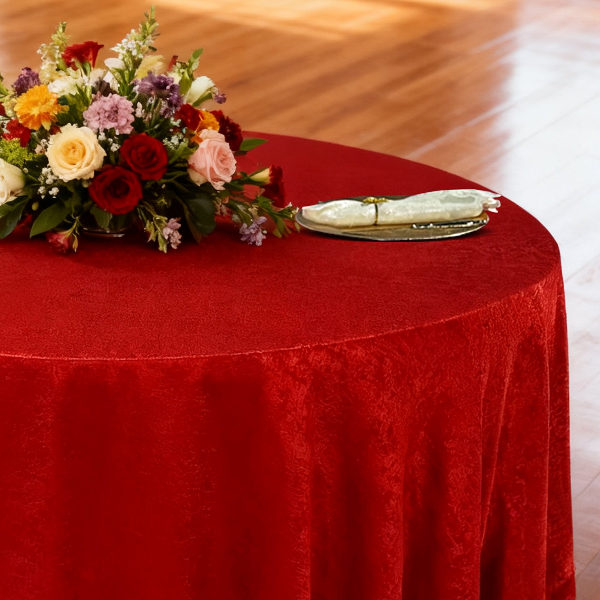 Crinkle Shimmer 120" Round Tablecloth Red table setting with floral centerpiece, ivory napkins and gold charger plate