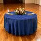 Crinkle Shimmer 132" Round Tablecloth Royal Blue with gold charger plates, ivory napkins, and a floral centerpiece