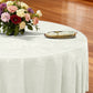 Crinkle Shimmer 132" Round Tablelcoth Ivory with a gold charger plate, ivory napkin with gold napkin ring and mixed floral centerpiece