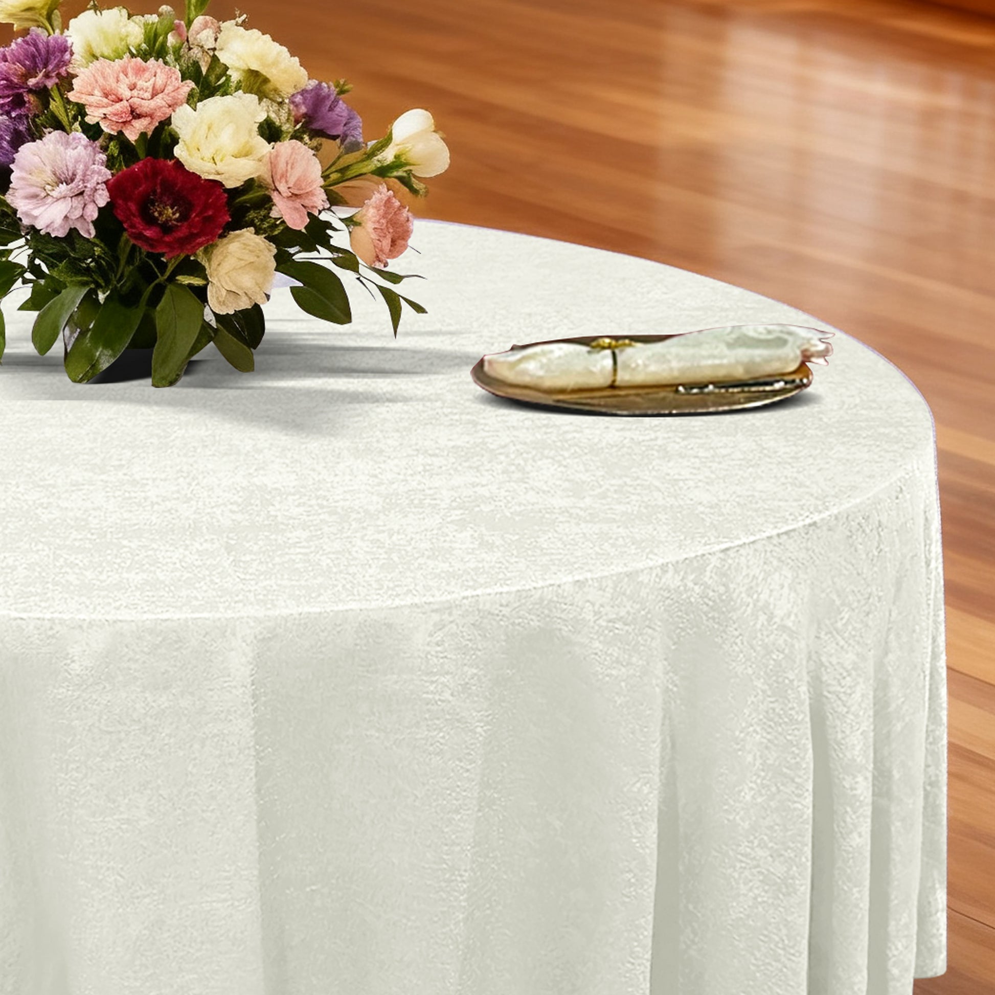 Crinkle Shimmer 132" Round Tablelcoth Ivory with a gold charger plate, ivory napkin with gold napkin ring and mixed floral centerpiece
