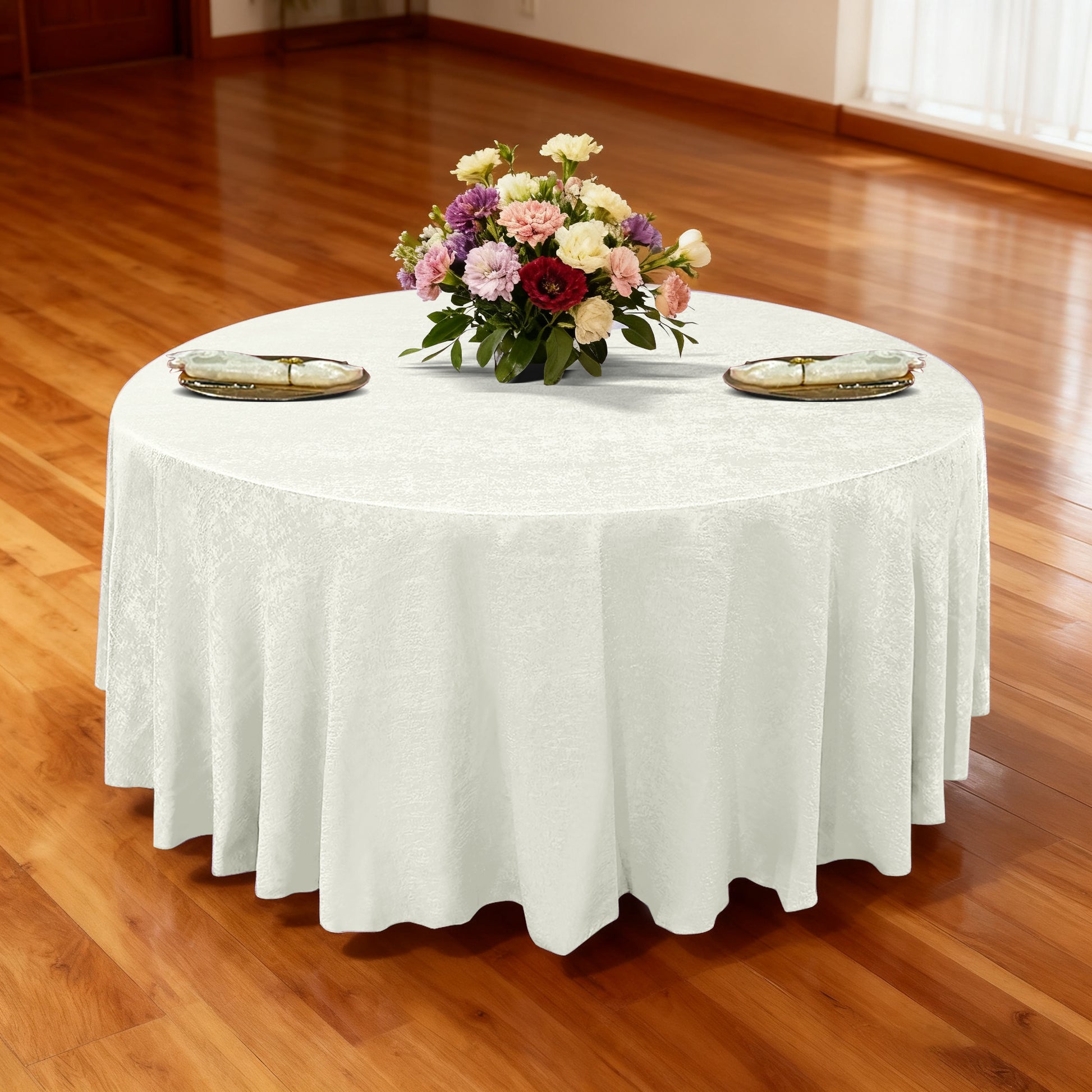 Crinkle Shimmer 132" Round Tablelcoth Ivory with a gold charger plates, ivory napkins with gold napkin rings and mixed floral centerpiece