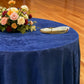 Crinkle Shimmer 132" Round Tablecloth Royal Blue with a floral centerpiece, gold charger plate and ivory napkin with a gold napkin ring