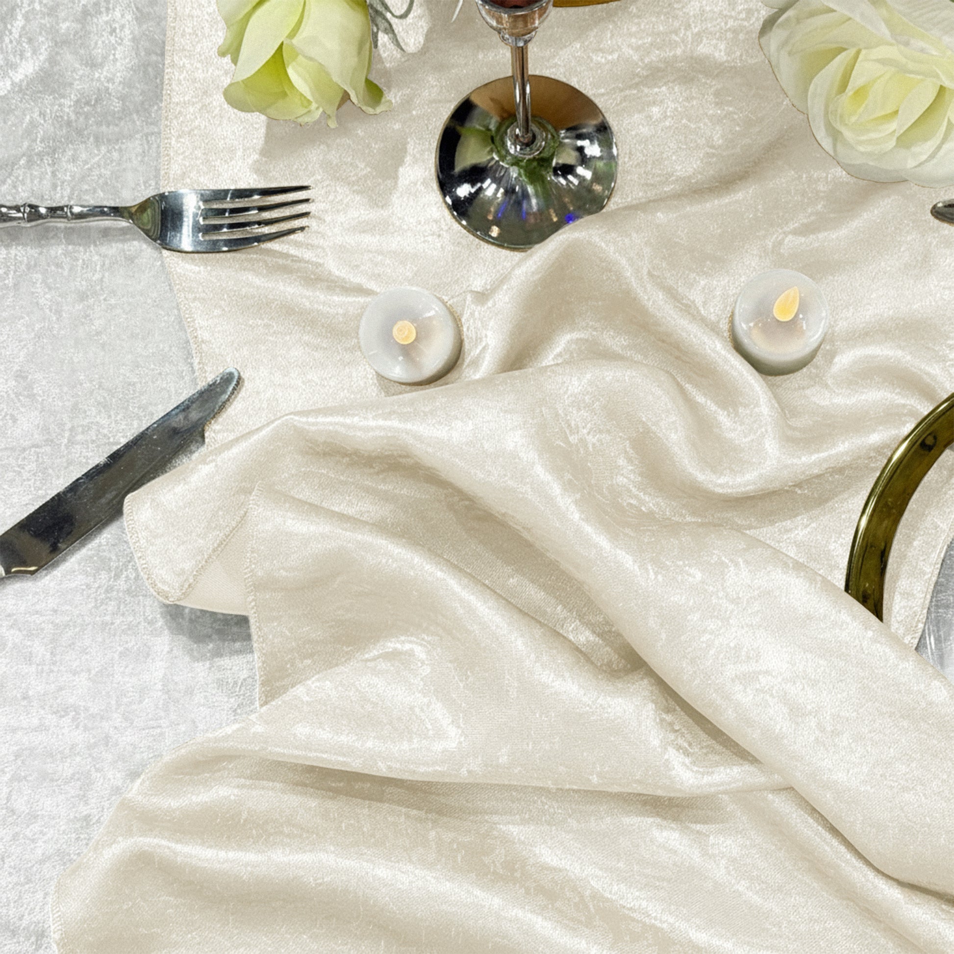 Crinkle Shimmer Table Runner Ivory bunched up with led tea light candels and white roses