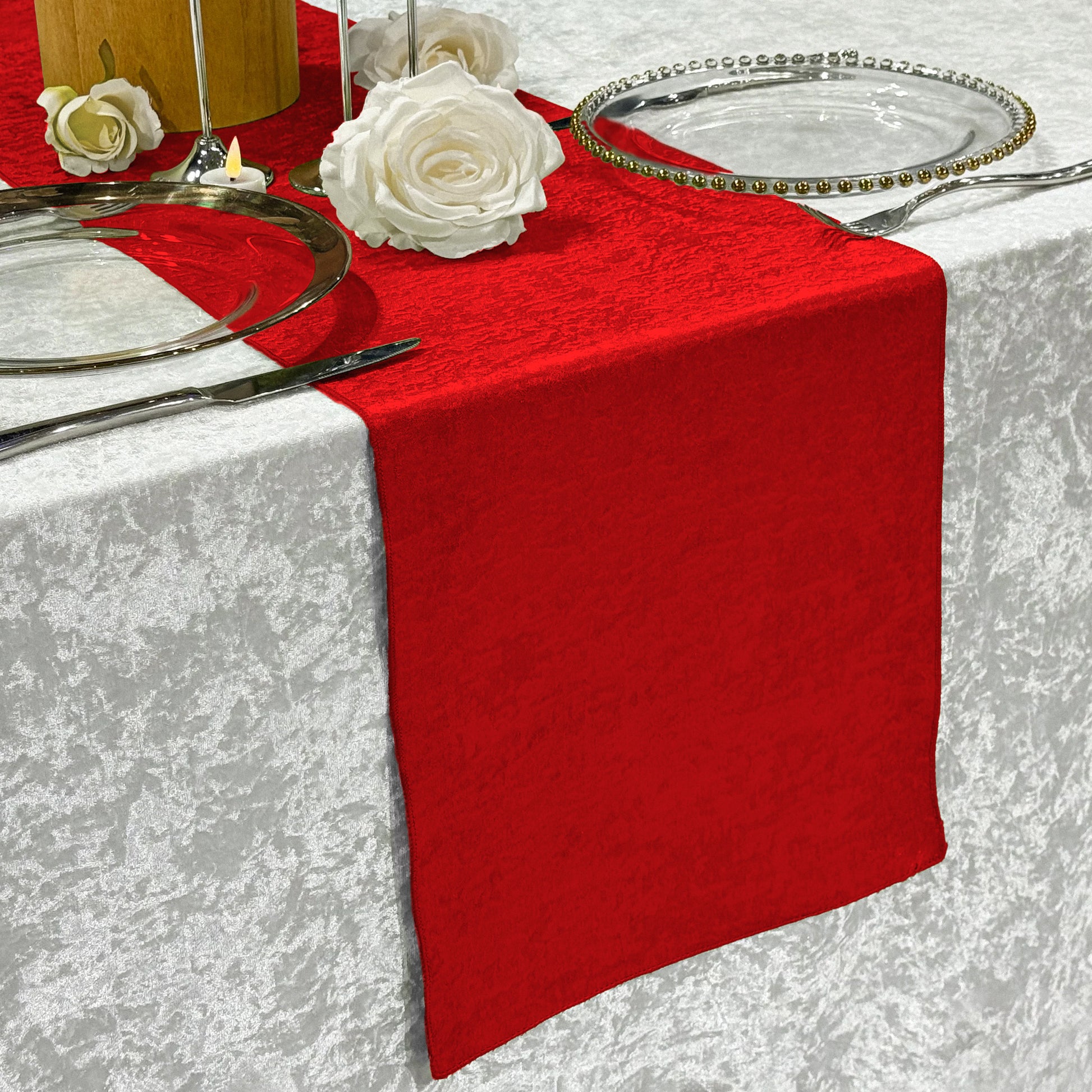 Crinkle Shimmer Table Runner Red on top a velvet silver tablecloth paired with glass charger plates and white roses