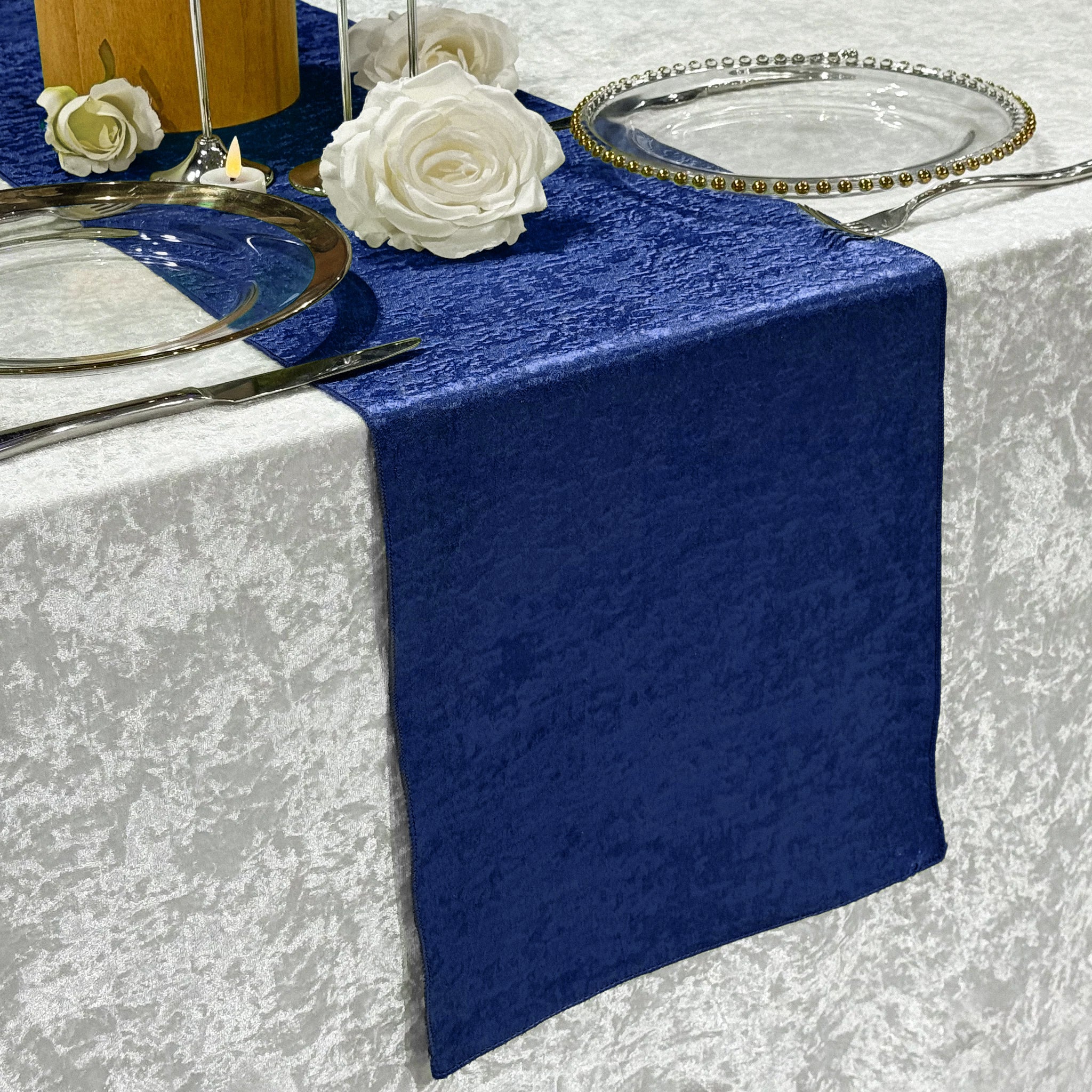 Crinkle Shimmer Table Runner Royal Blue ontop a velvet silver tablelcoth, white roses, and charger plates.