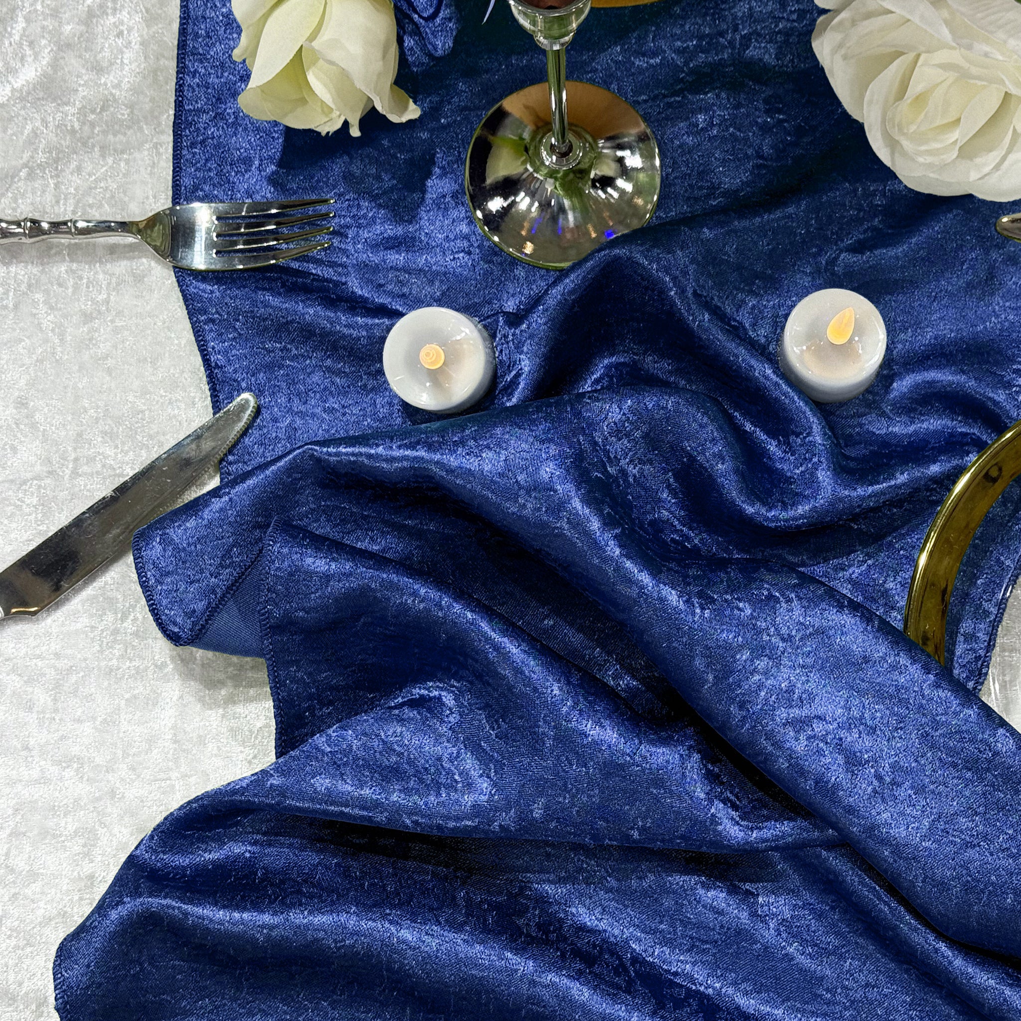 Crinkle Shimmer Table Runner Royal Blue bunched up with led tea light candels and white roses