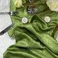Crinkle Shimmer Table Runner Willow Green bunched with silver flatware, LED tea light candles
