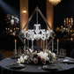 Diamond Shape Centerpiece with Hanging Chandelier Silver on top a black tablecloth with black dinnerware and mixed florals at the base